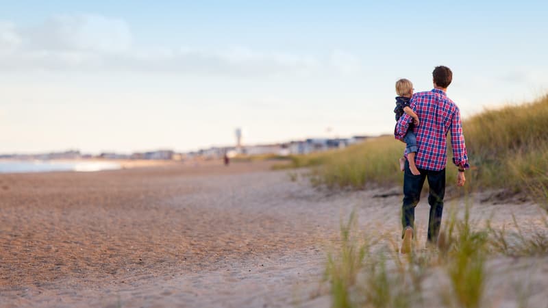 Ein Mann mit seinem Kind am Strand